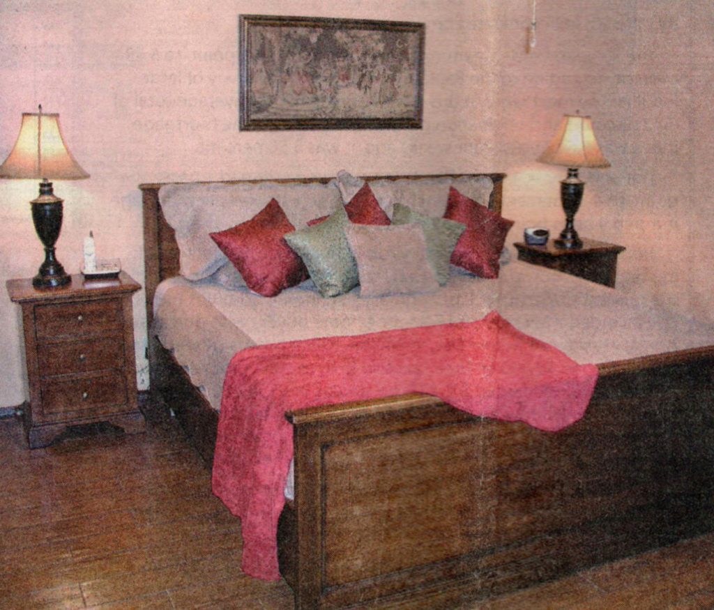 A bed room with two lamps and a large bed
