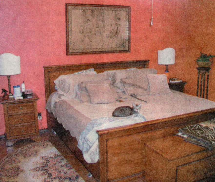 A bed room with a large wooden bed and two night stands