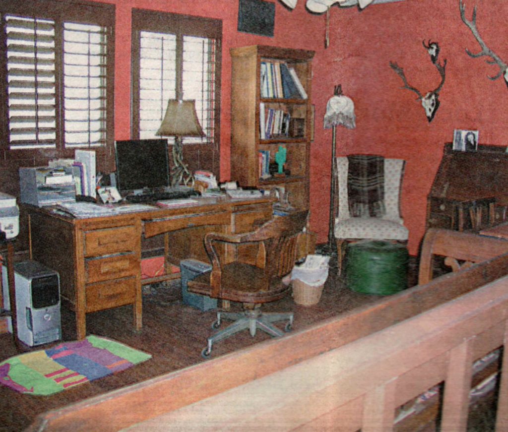 A painting of an office with a desk and chair.